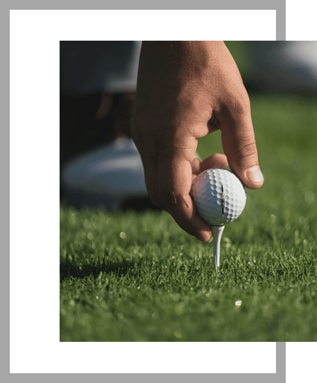 A person holding a golf ball on the ground