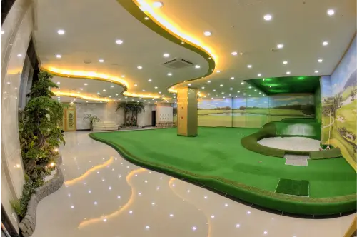 A room with a green golf course in the middle of it