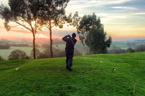 A man standing on top of a green field.